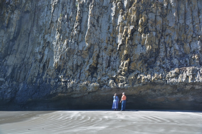 tiny people against a huge rock